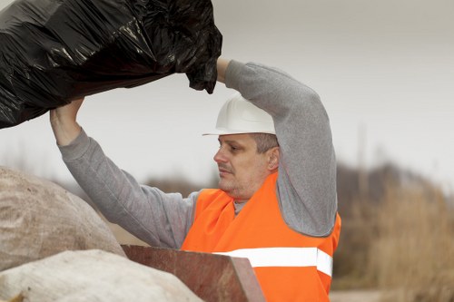 Man and van team loading waste at a mixed-use property in Reigate